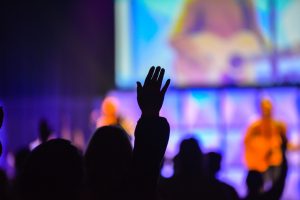 Worshipers holding their hands in the air at a Christian worship service